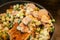 Assorted frozen vegetables on a wooden spatula over the pan