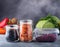 Assorted fruits veggies and legumes in containers on a dark background