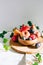 Assorted fruits in a wooden plate on a marble background, green ivy mango, peach, plum, pear, pomegranate