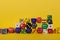 Assorted game dice randomly stacked on a yellow background