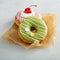 Assorted glazed fried donuts on parchment