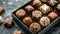 Assorted gourmet chocolates in a luxury box on a dark background.