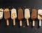 Assorted gourmet ice cream popsicles with toppings on black background