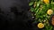Assorted green salad with vegetables, seeds, and olive oil on black stone background, top view