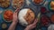 Assorted Indian ethnic food buffet on rustic concrete table from above