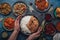 Assorted Indian ethnic food buffet on rustic concrete table from above