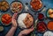 Assorted Indian ethnic food buffet on rustic concrete table from above