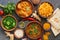 Assorted Indian food on a dark rustic background. Traditional Indian dish Chicken tikka masala, palak paneer, saffron rice, lentil