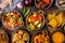 Assorted indian food set on wooden background. Dishes and appetisers of indeed cuisine, rice, lentils, paneer, samosa, spices, mas