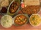 Assorted indian food on wooden background. Pepper chicken,paneer butter masala, jeera rice & chapati..Dishes and appetizers of