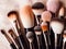 Assorted makeup brushes with copy space, beauty artist workspace, bunch of different brushes on blurred background