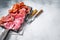 Assorted meat appetizers - salami, jamon, choriso sausages. White background. Top view. Copy space