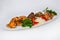 Assorted meat with fresh vegetables on an oval white plate