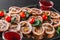 Assorted meat, stuffed chicken rolls, meat rolls stuffed with mushrooms, cranberries and dried apricots on black shale background