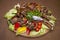 Assorted meat with vegetables on a wooden plate
