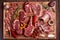 Assorted minced meat ingredients - rack of calf, ribeye, rack of lamb, with garlic, onions, red and yellow tomatoes, red pepper