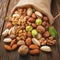 Assorted nuts spilling from linen bag onto rustic wooden table
