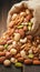 Assorted nuts spilling from linen bag onto rustic wooden table