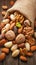 Assorted nuts spilling from linen bag onto rustic wooden table