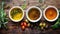 Assorted olive oils with herbs and spices on a wooden table.