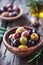 Assorted Olives in a Clay Bowl With Olive Oil and Rosemary on a Rustic Wooden Table