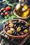 Assorted Olives in a Clay Bowl With Olive Oil and Rosemary on a Rustic Wooden Table