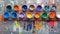 Assorted open paint cans on vibrant multicolored background for artistic projects