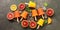 Assorted orange popsicles with slices of citrus, mint and ice on a dark rustic background, border. Frozen juice of red and yellow