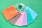 Assorted paper bags in various pastel colors, flat lay on green paper