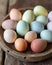 Assorted pastel-colored Easter eggs on a rustic wooden platter, holiday celebration.