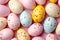 Assorted pastel-colored plastic Easter eggs with brown spots on a pink background