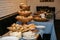 Assorted pastries showcased on a table against a brick backdrop