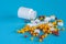 Assorted pharmaceutical medicine pills, tablets and capsules and bottle, syringe on blue background