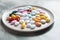 Assorted pills are in a white plate. Different tablets and capsules. Copy space