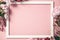 Assorted pink flower and white frame border on pink background, flat lay