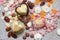 Assorted pink, orange, brown and green chocolate hearts with meringues, pecan nuts and chocolate drops on grey background