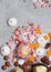 Assorted pink, orange, brown and green chocolate hearts with meringues, pecan nuts and chocolate drops on grey background