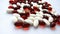 Assorted red and white pharmaceutical medicine pills, tablets and capsules on white background. Pharmacy theme, health care, drug