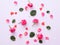 Assorted rose heads. Various soft roses and leaves scattered on pink background, top view