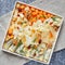 Assorted sorts of cheese on a wooden plate, grey background, top view