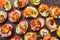 Assorted spanish tapas with fish, sausage, cheese and vegetables. Dark background, top view