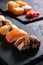 Assorted sushi with salmon, eel and escolar on black stone plate on dark background