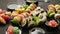 Assorted sushi set served on dark dark background. Top view of seafood, various maki rolls