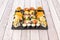 Assorted sushi tray with nori seaweed maki, uramaki california roll with masago roe, raw salmon nigiri, flambÃ© salmon, crispy