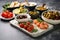 assorted tapas in white ceramic dishes against a stone backdrop