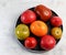 Assorted tomatoes on a round plate on a light gray background