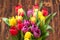 Assorted Tulips Bouquet. Burned Wooden Background. Copy Space