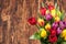 Assorted Tulips Bouquet. Burned Wooden Background. Copy Space