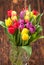 Assorted Tulips Bouquet. Burned Wooden Background. Copy Space
