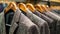 Assorted tweed jackets on wooden hangers in a retail clothing store